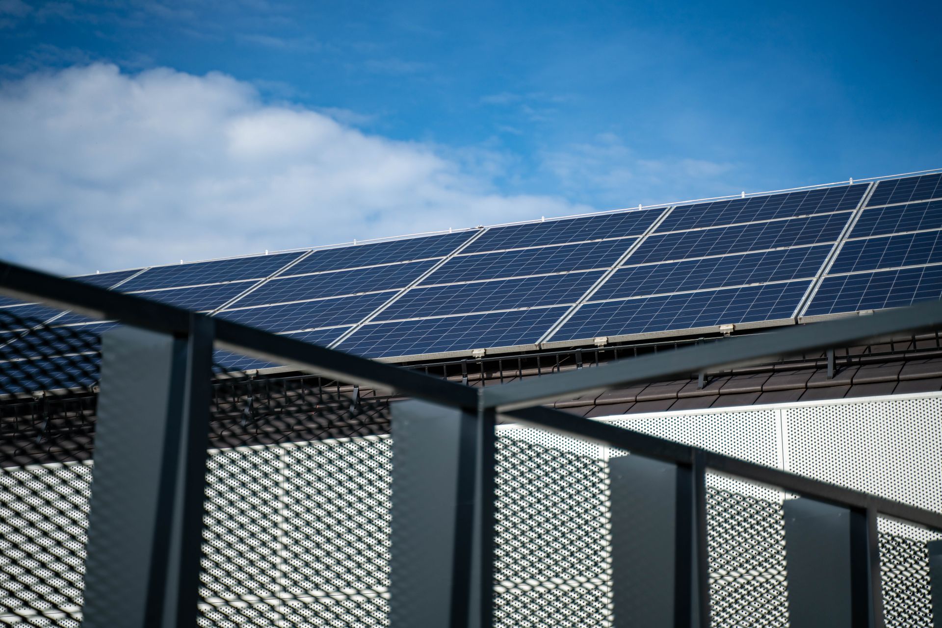 Large solar panels mounted on a roof under a blue sky