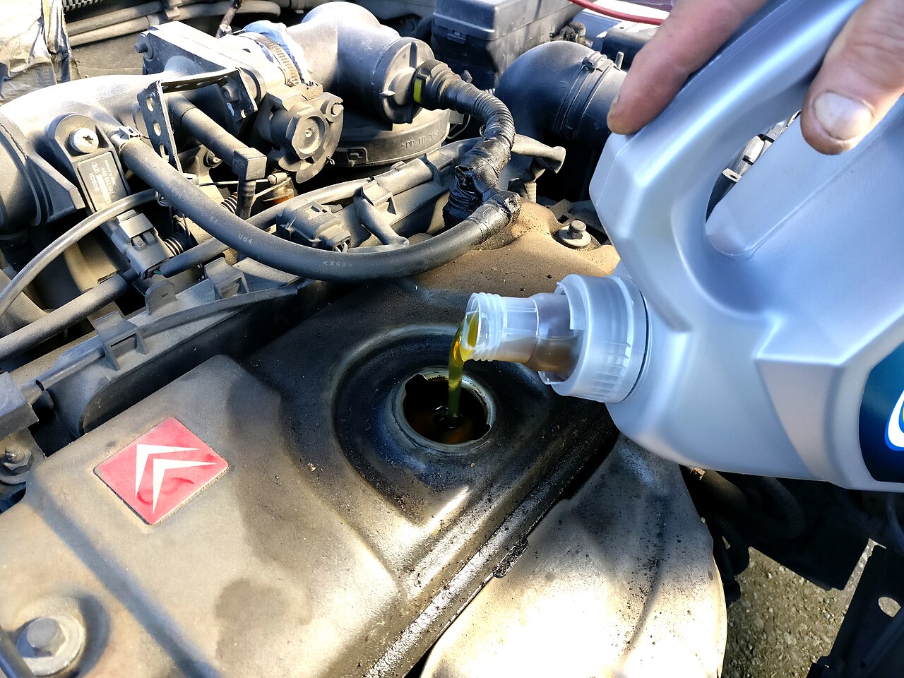 Pouring fresh engine oil during a small-engine oil change